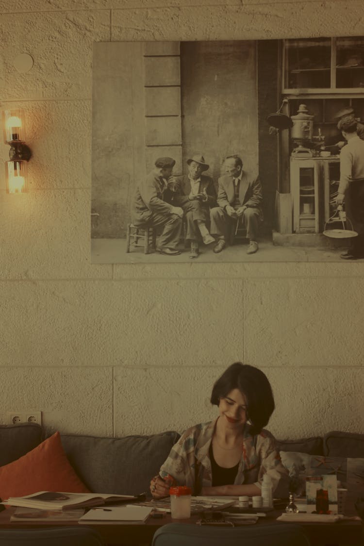 Young Brunette Woman Drawing At The Table