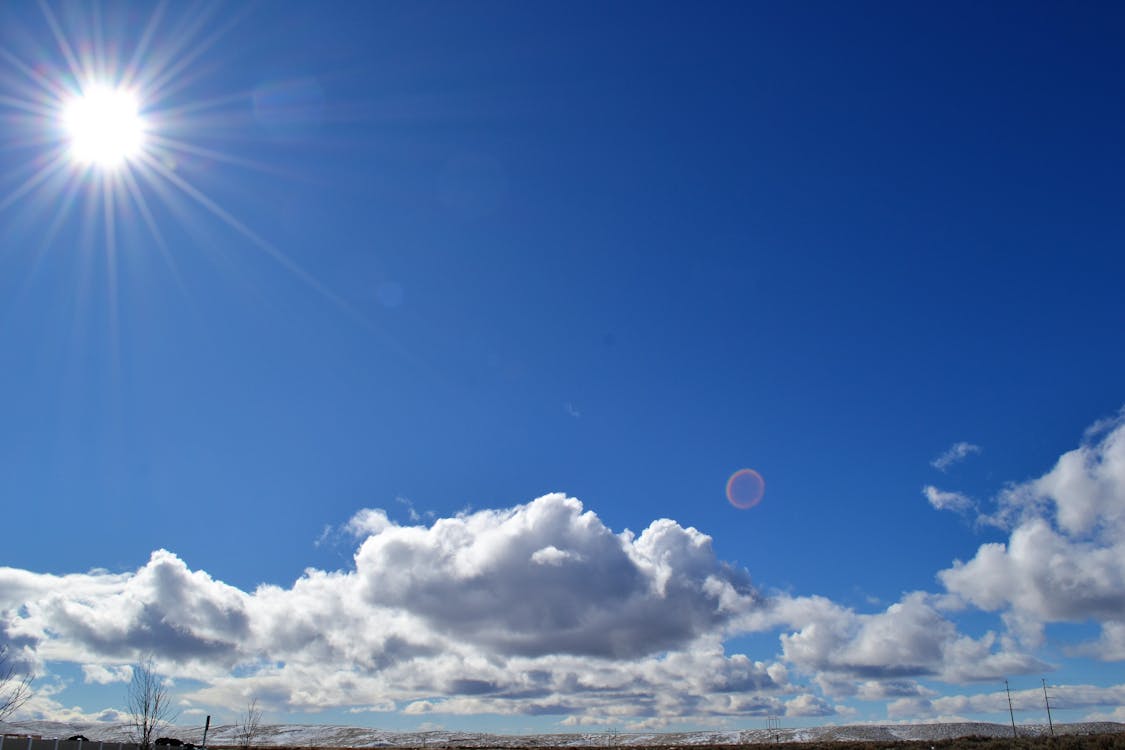 Cloudy blue sky with the Sun