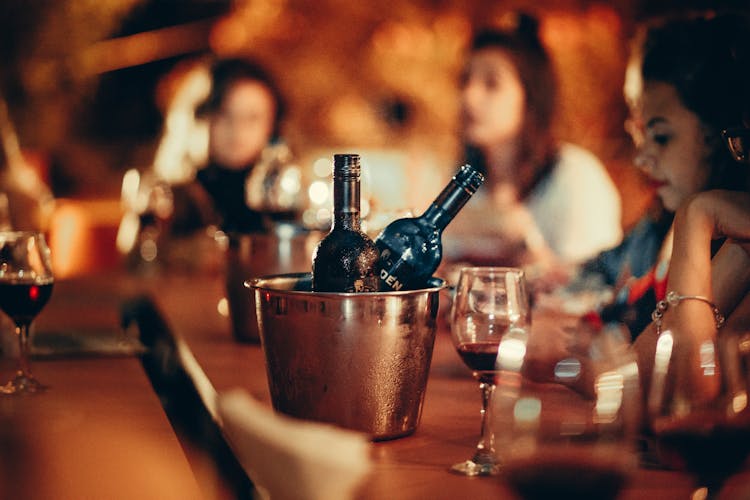 Wine Bottles And Glasses On Bar Counter