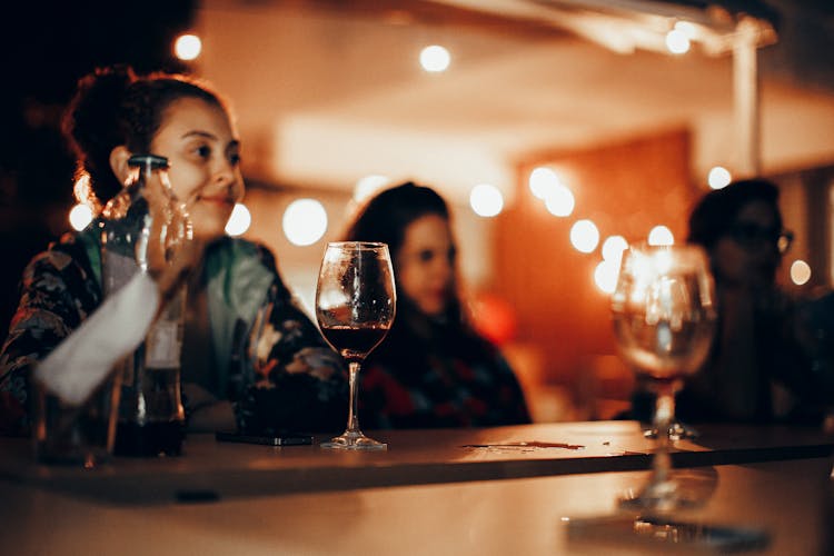 People Sitting At Counter In Bar