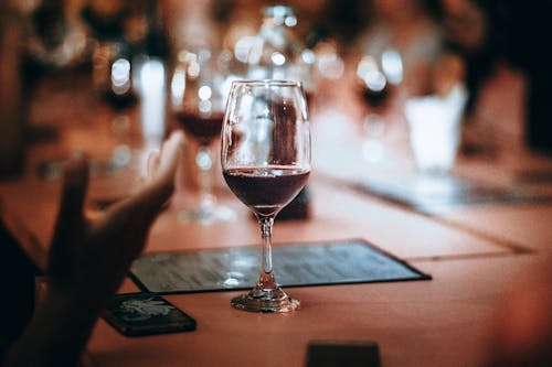 Clear Wine Glass on Brown Wooden Table