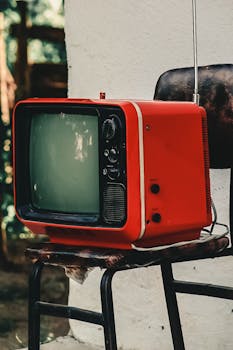 Retro red television set on a rustic chair, perfect for vintage-themed projects.