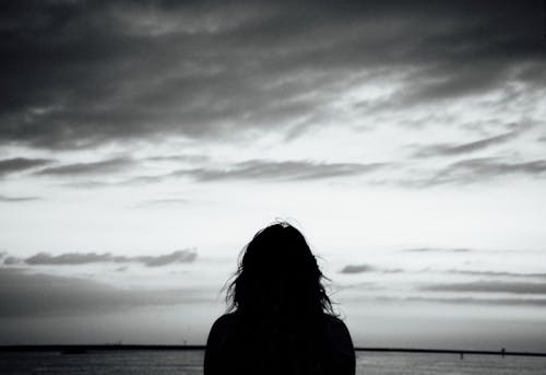 Silhouette of Woman under Cloudy Sky 