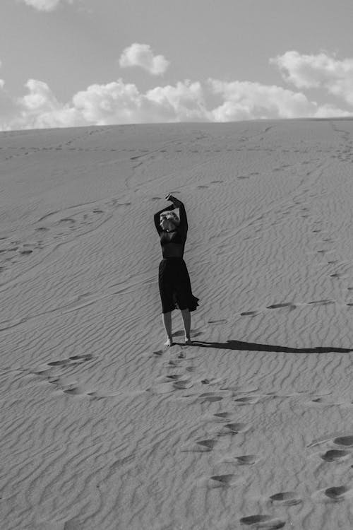 Woman in Dress standing in the Middle of Desert 