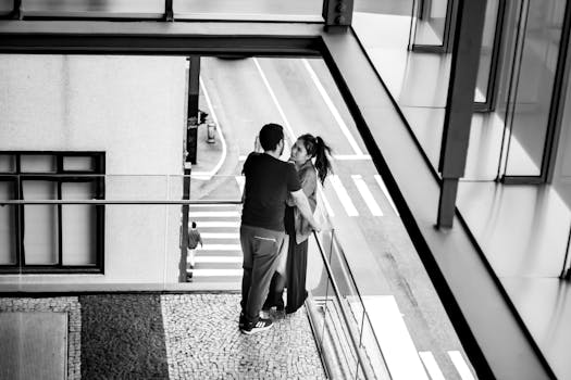 A couple shares a tender moment on a Sao Paulo balcony, captured in black and white.