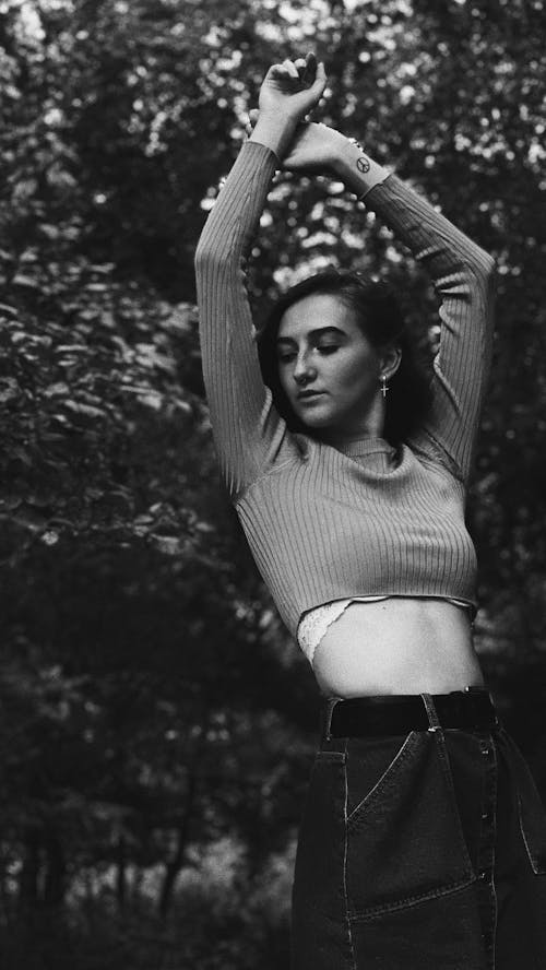 A Woman in Long Sleeves Crop Top Standing Near the Trees