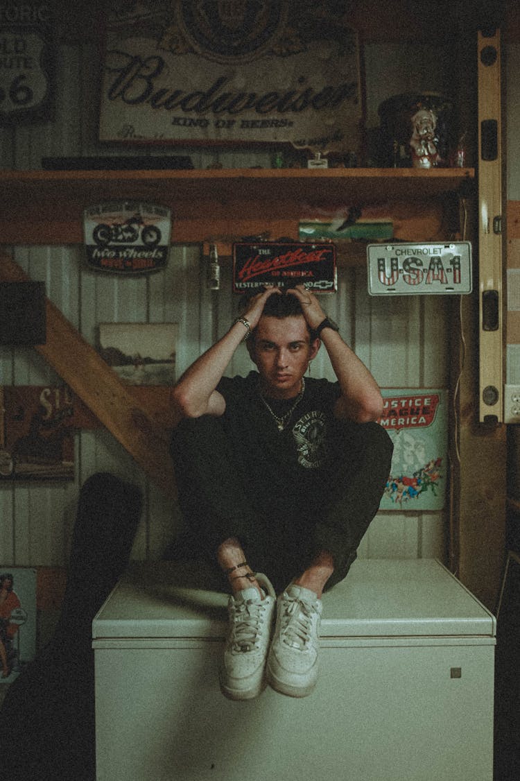 A Man Sitting On The Freezer Top