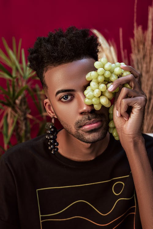 Man in Black Crew Neck Shirt Holding Green Grapes