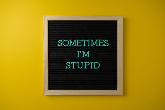 A letter board with a humorous message on a vibrant yellow background.