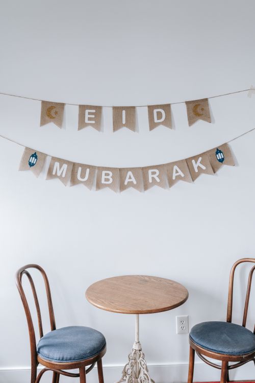Free A minimalistic and cozy home setup for Eid Mubarak with banners and chairs. Stock Photo