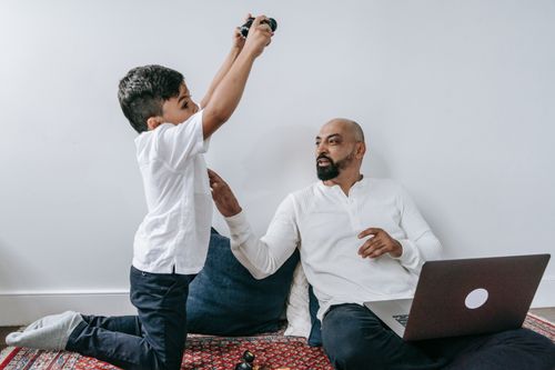 Free Father and son spending quality time at home, enjoying playful interaction with technology. Stock Photo