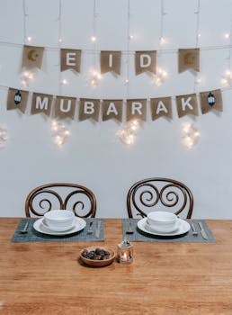 Elegant Eid Mubarak dining table setup with decorative lights and traditional settings.