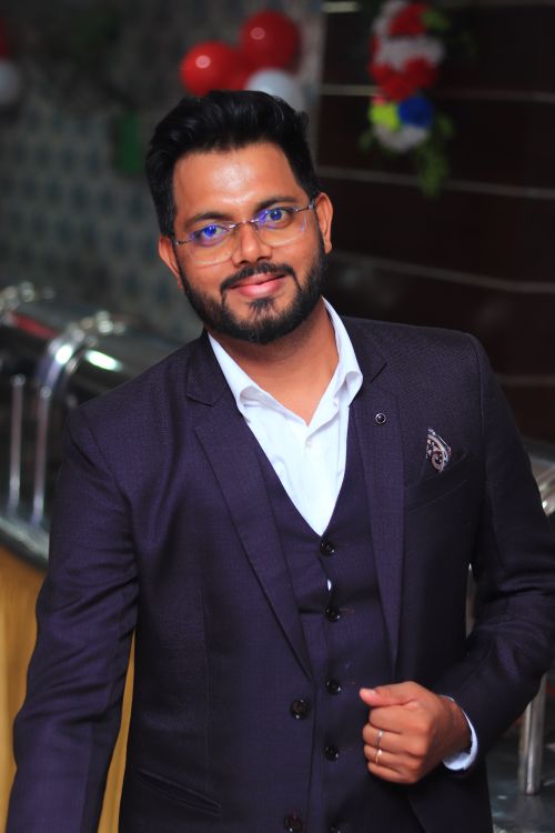 Free Stylish man in a dark suit smiling confidently indoors. Stock Photo