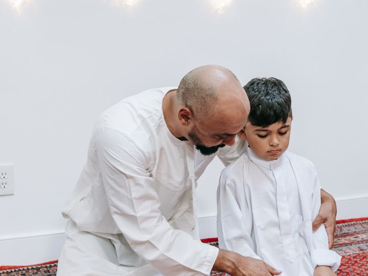 Father teaching his son how to pray Salah