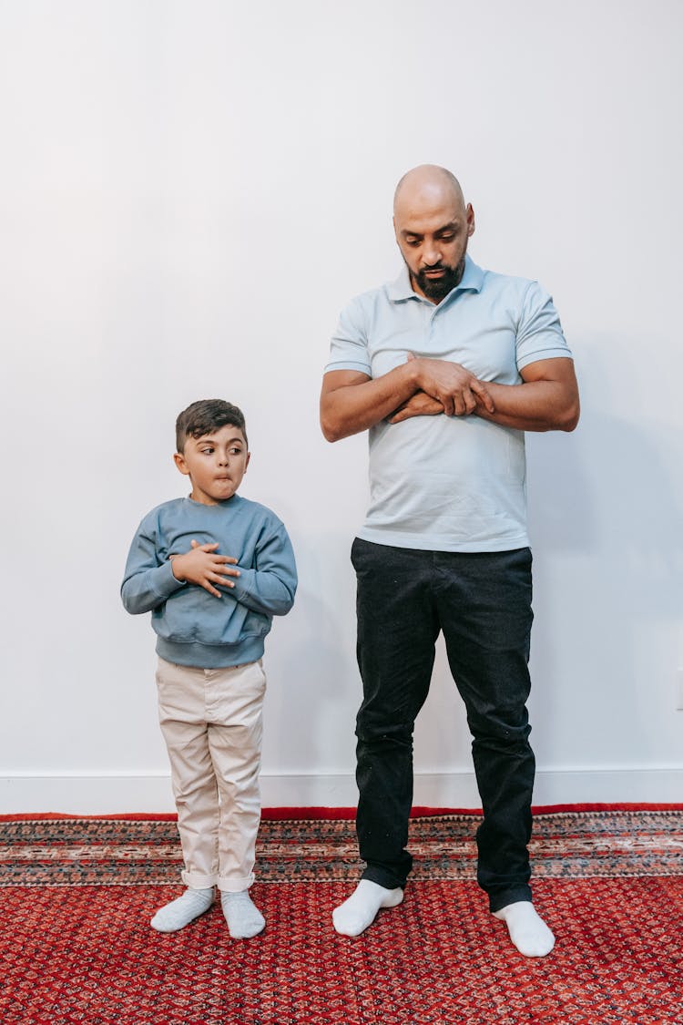 Father And Child Praying Standing On Carpet