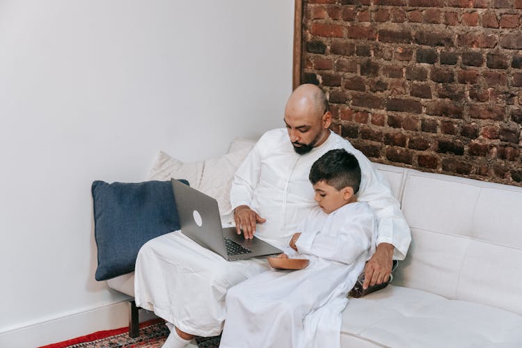 Muslim Father And Son Using Computer At Home