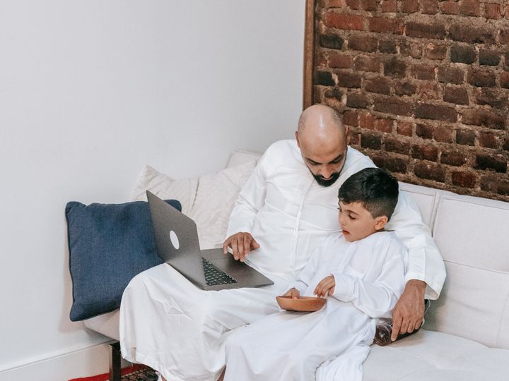 Father and son learning together on a laptop at home