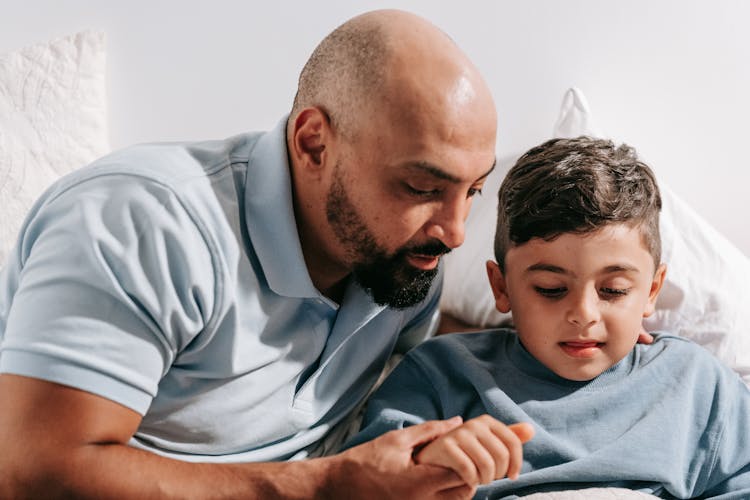 Man In Blue Polo Shirt Holding Child's Hand