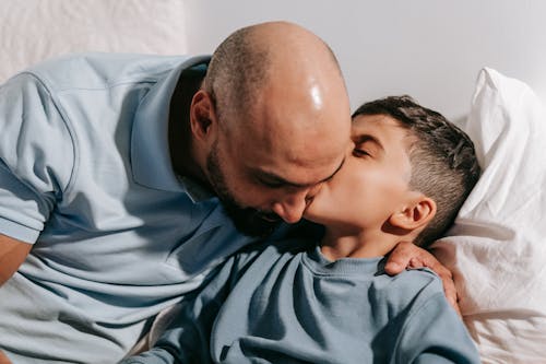 Close-Up Shot of a Boy Kissing His Father