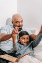 Father and Son Sitting on Bed