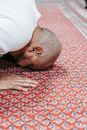 A Man in White Shirt Head Down on a Red Rug