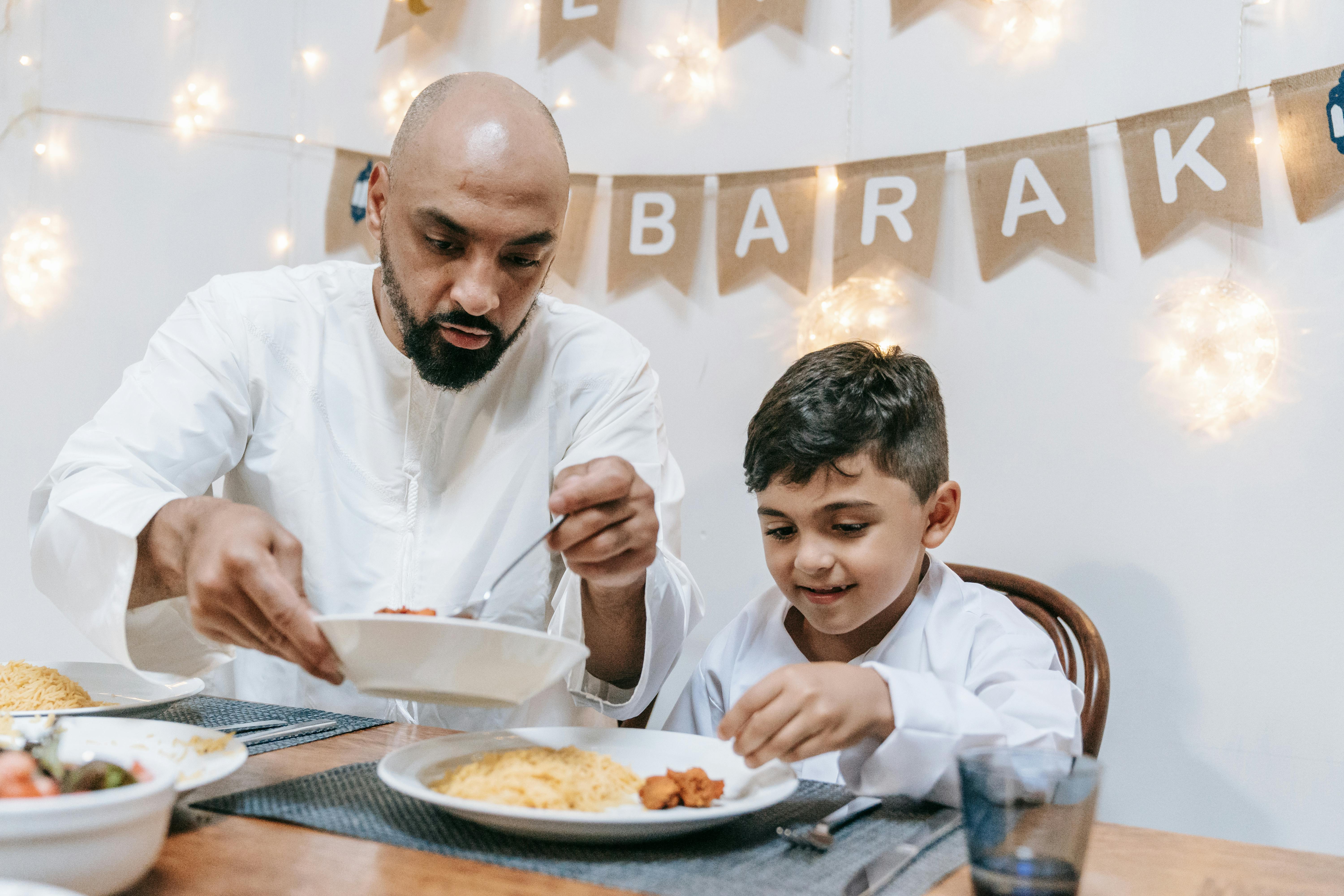 Father and son enjoying a festive Eid meal together, creating warm family moments.