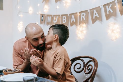 Free A touching moment between a father and son during an Eid Mubarak celebration indoors. Stock Photo