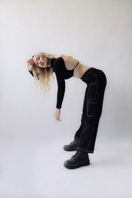 Stylish woman posing in modern black attire, creating a contemporary fashion statement.