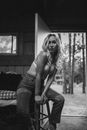 Woman in Denim Jeans Sitting on a Wooden Stool