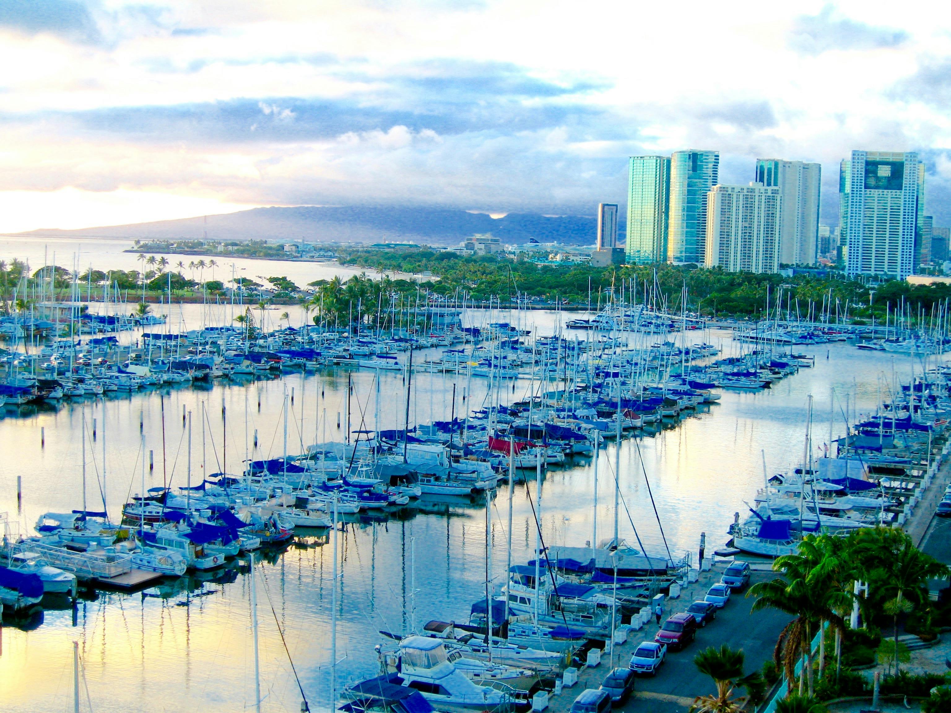 Picturesque harbor with yachts and city skyline in Honolulu, Hawaii during daytime.