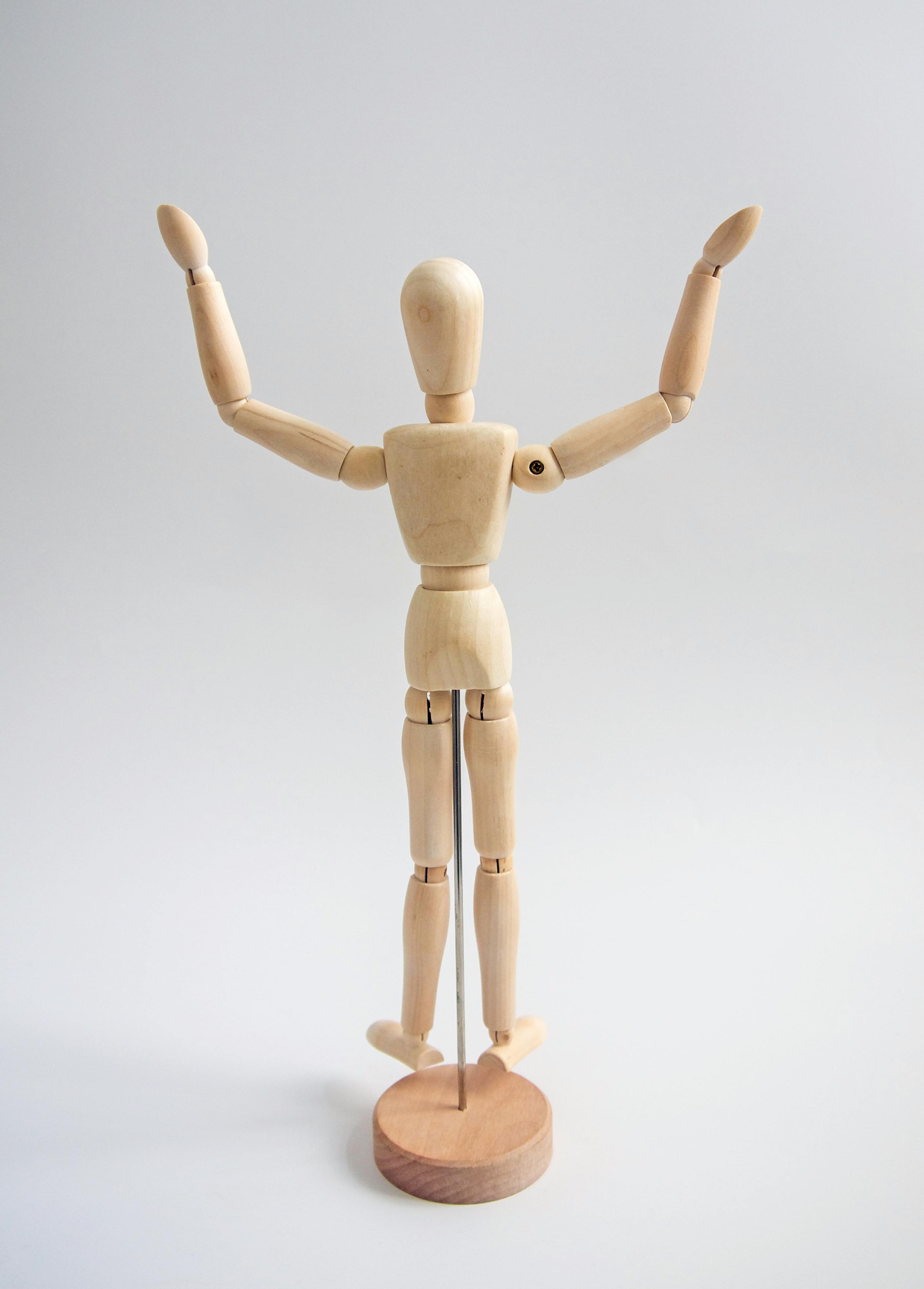 wooden human figure on white table