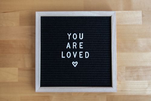 Free A black letter board with the motivational message 'You Are Loved' in white letters. Stock Photo