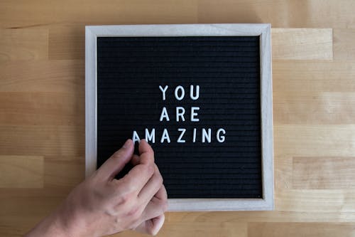Free A Person Posting a Message on a Black Letter Board Stock Photo