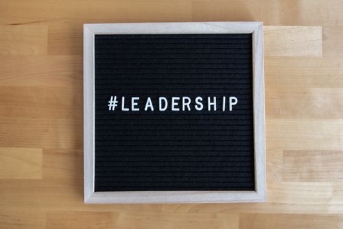 Free A black letter board with white hashtag leadership text on wooden surface, inspiring leadership theme. Stock Photo