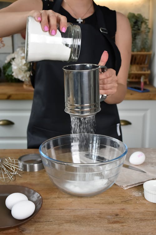 Free Woman Sieving Flour to a Glass Bowl  Stock Photo