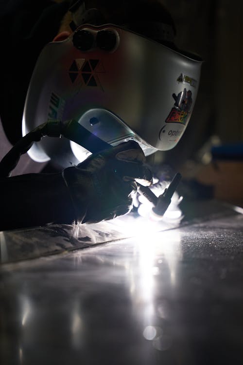 A Person Wearing a Protective Head Shield Welding Metals
