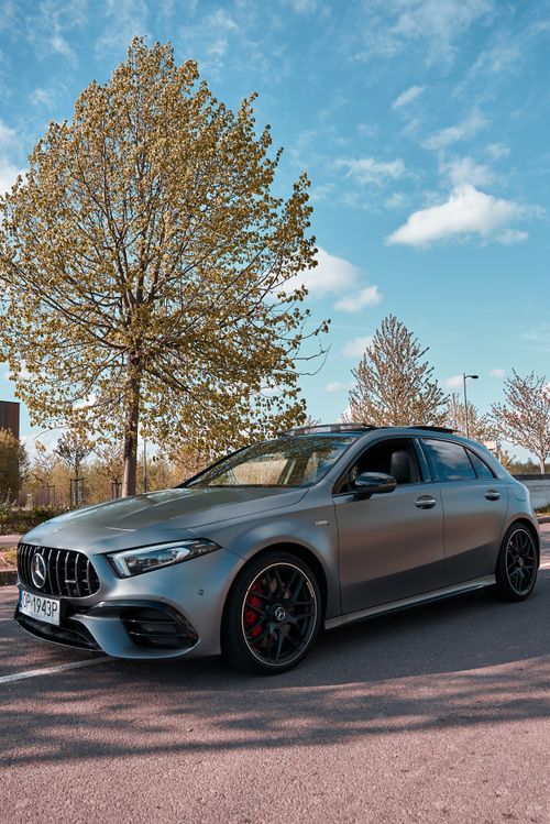 Free Luxurious Mercedes-Benz on a scenic road in daylight with clear skies and trees. Stock Photo