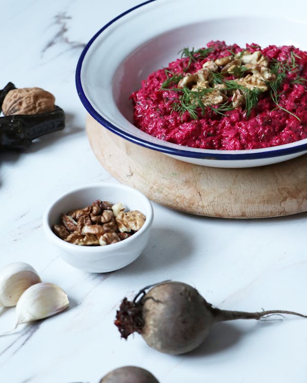 a bowl of beetroot salad and beetroot and nuts on a table