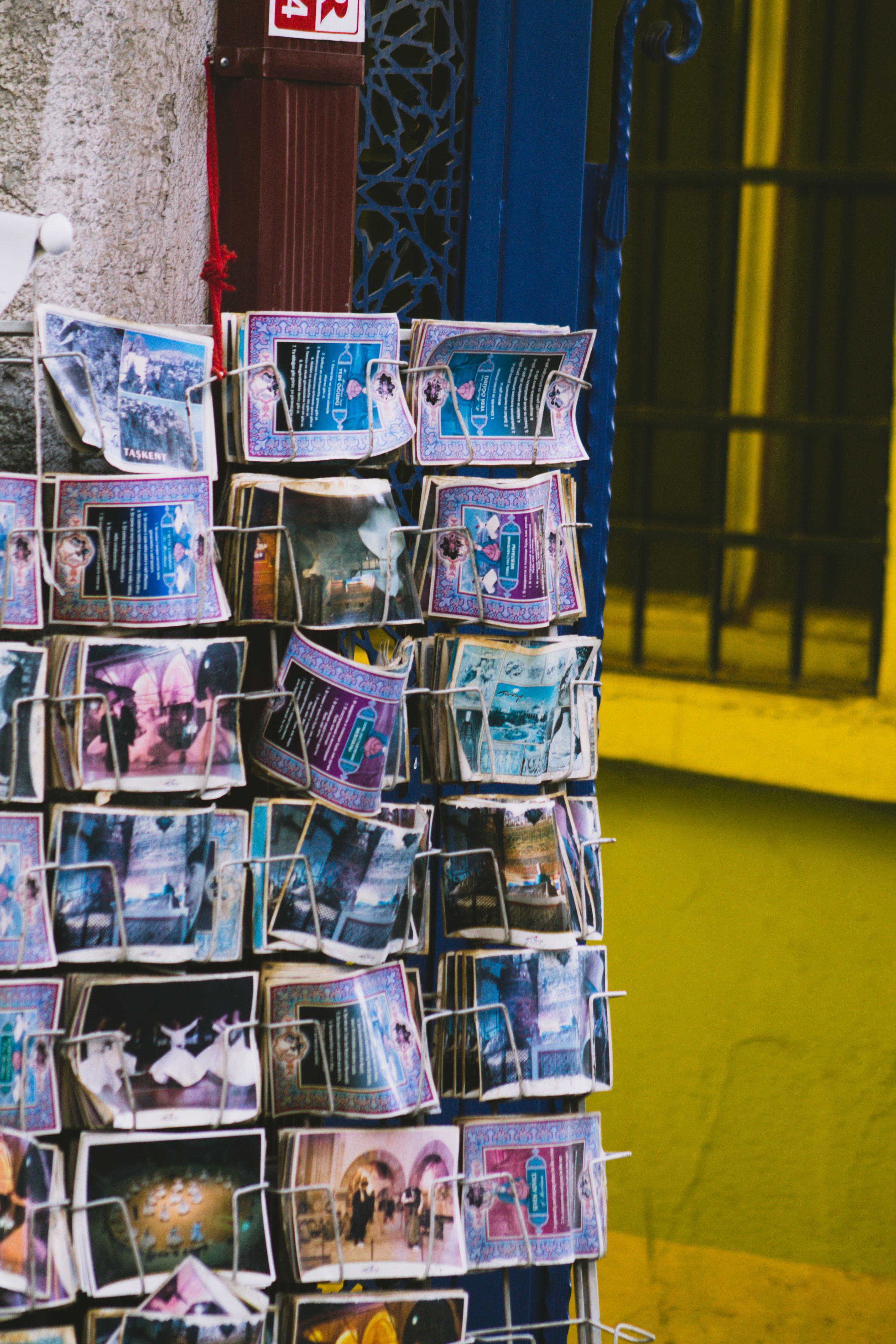 Colorful postcards on a vibrant street stand, perfect for travel memories.
