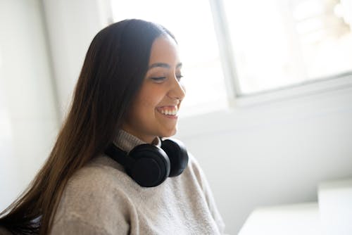 Free Woman in Gray Sweater Wearing a Black Headphones Stock Photo