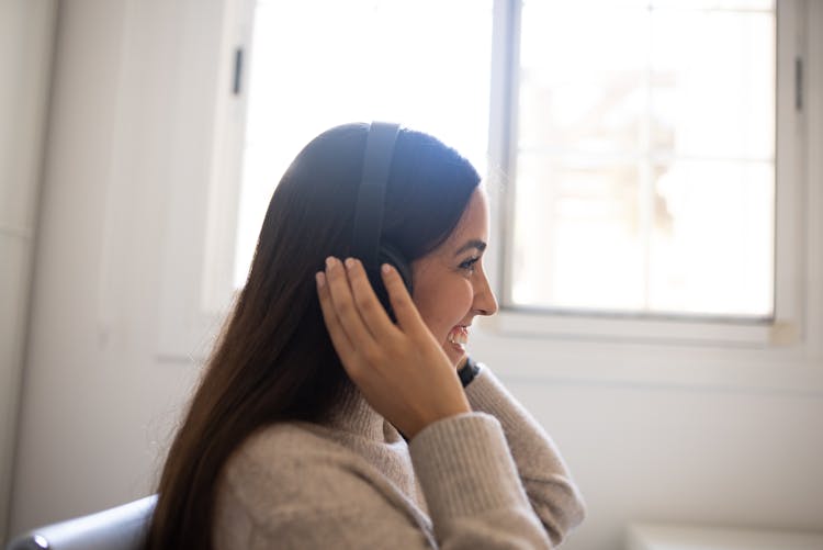 A Profile Of A Young Woman With Headphones Smiling