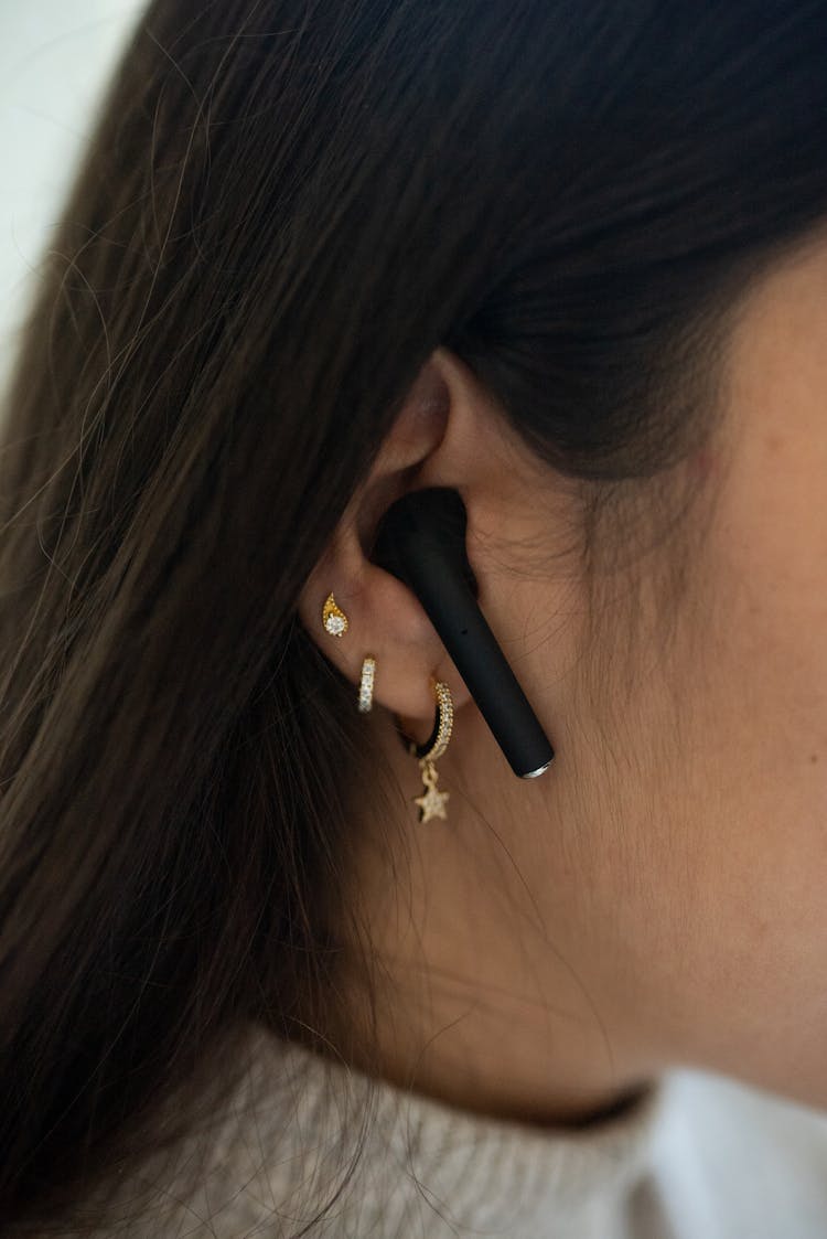 A Brunet Haired Woman Using Black AirPod