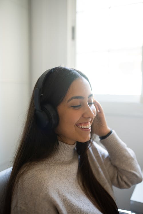 Free Woman in Gray Sweater Wearing Black Headphones Stock Photo