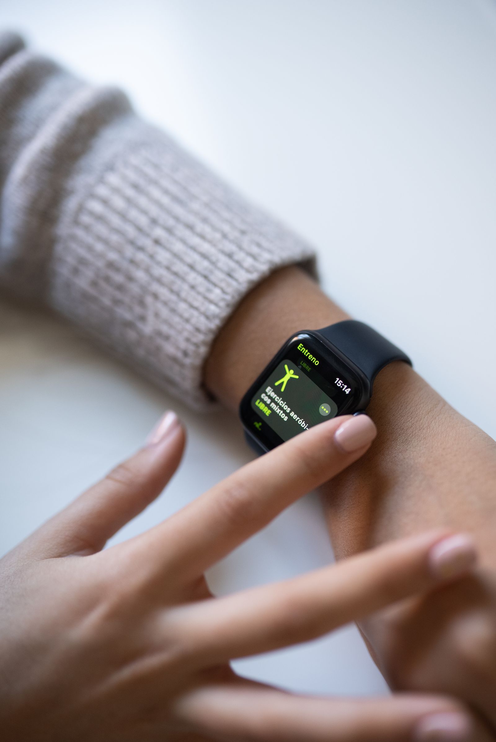 Person interacting with a black smartwatch during health tracking.