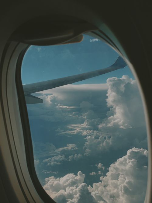 Free A scenic aerial view of clouds from an airplane window during a daytime flight. Stock Photo