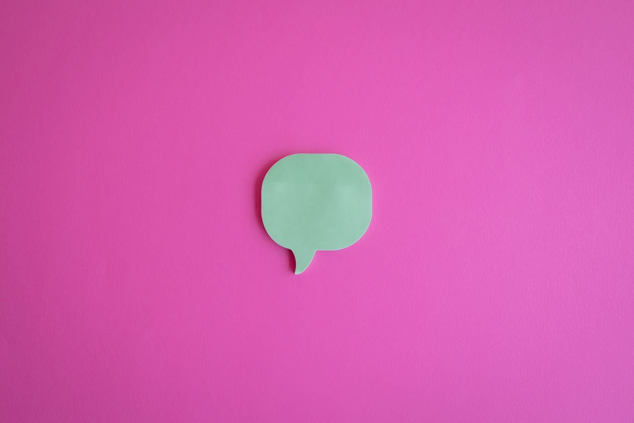 Green speech bubble on a vibrant pink background representing word of mouth and the Viral Referral Method
