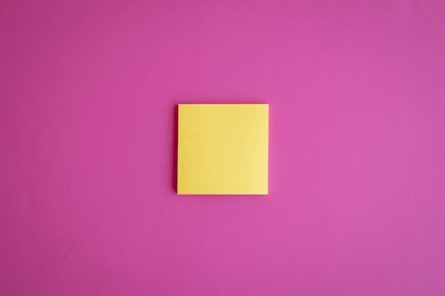 Yellow Sticky Note on Pink Surface