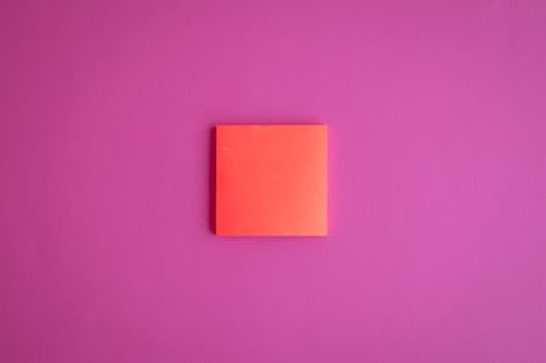 Red Sticky Note on Pink Surface