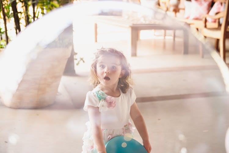 Girl Looking At Big Toy Ball