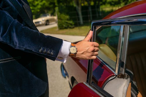 Person in Black Suit Jacket Wearing Brown Analog Watch